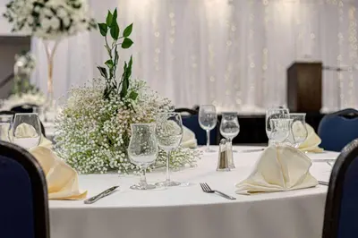 a table with wine glasses and a flower arrangement on it at Wyndham Edmonton Hotel and Conference Centre in Edmonton