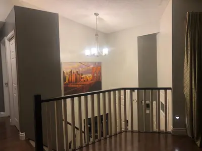 a room with a staircase with a painting on the wall at Citadel hill cr community! in Calgary
