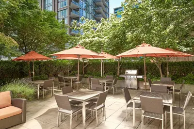 an outdoor patio with tables and chairs and umbrellas at Residence Inn by Marriott Vancouver Downtown in Vancouver