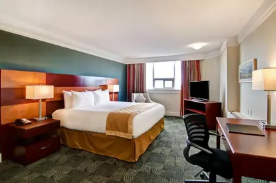 a hotel room with a bed and a desk at Edmonton Inn and Conference Centre in Edmonton