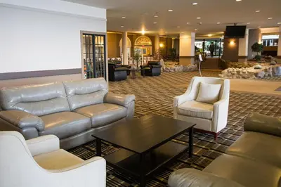 a lobby with couches and a table and chairs at Edmonton Inn and Conference Centre in Edmonton