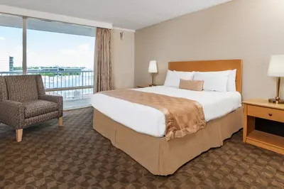 a hotel room with a bed and a chair and a window at Edmonton Inn and Conference Centre in Edmonton