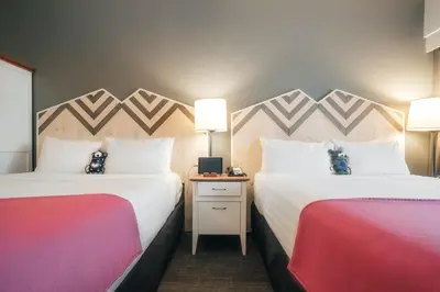 a hotel room with two beds and a table with lamps at Summit Lodge Boutique Hotel by Paradox in Whistler