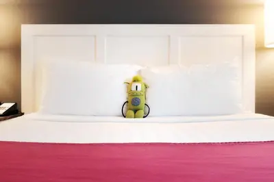 a teddy bear sitting on top of a bed at Summit Lodge Boutique Hotel by Paradox in Whistler