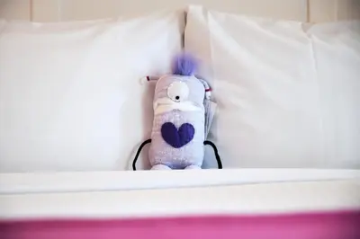 a stuffed animal is sitting on a bed at Summit Lodge Boutique Hotel by Paradox in Whistler