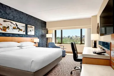 a hotel room with a bed and a desk with a computer at Delta Hotels by Marriott Calgary Downtown in Calgary