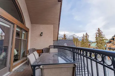 a balcony with a table and chairs on it at Cascade Penthouse by Canadian Rockies Vacation Rentals in Canmore