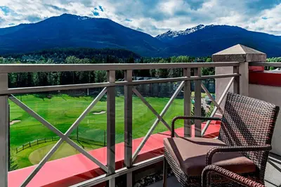 a balcony with a chair and a view of a golf course at The Westin Resort & Spa, Whistler in Whistler