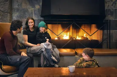a group of people sitting in front of a fireplace at The Westin Resort & Spa, Whistler in Whistler