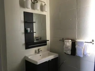 a white bathroom with a sink and a mirror at Howard Johnson by Wyndham Grande Prairie in Grande Prairie
