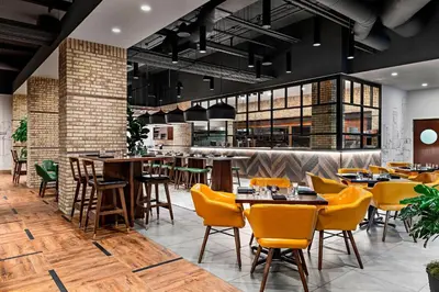 a restaurant with tables and chairs and a bar at Sheraton Suites Calgary Eau Claire in Calgary