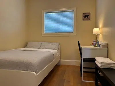 a bedroom with a bed and a desk and a window at Victory House in Burnaby