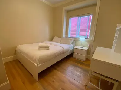 a small bedroom with a bed and a window at Victory House in Burnaby
