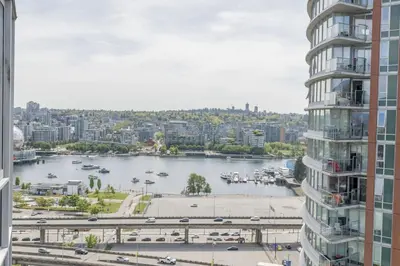 a view of a river from a building at Two Bedroom Apartment with stunning 180 water, mountain and city view Pool Hot Tub and Gym Heart of Downtown Skytrain 3mins walk Right by BC Place Rogers arena in Vancouver
