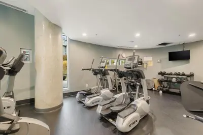 a gym with a row of exercise bikes in a room at Two Bedroom Apartment with stunning 180 water, mountain and city view Pool Hot Tub and Gym Heart of Downtown Skytrain 3mins walk Right by BC Place Rogers arena in Vancouver