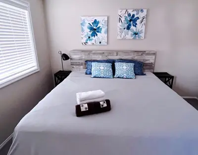 a bedroom with a large white bed with blue pillows at Banff -Calgary Garden &3 mins Bus station Close C-Train&Free Parking in Calgary