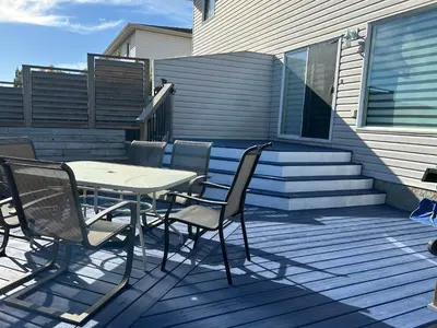 a patio with a table and chairs on a deck at Spacious Duplex in Camrose
