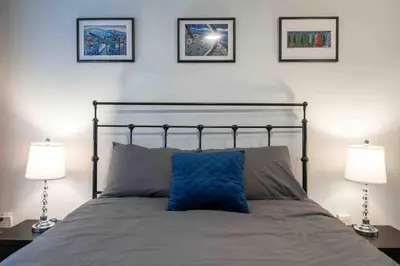 a bed with two lamps and a blue pillow on it at Updated Townhouse in Village. Pool/Hot Tub/Parking in Whistler