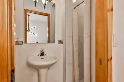 a bathroom with a sink and a mirror and a shower at Banff Gate vacation townhouse in Canmore