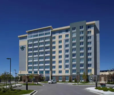 a large building with a car parked in front of it at Homewood Suites Calgary Airport in Calgary
