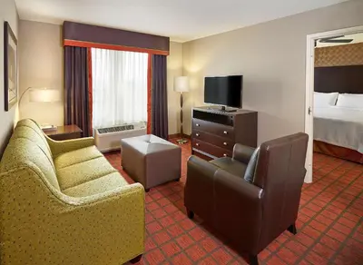 a hotel room with two chairs and a bed at Homewood Suites Calgary Airport in Calgary