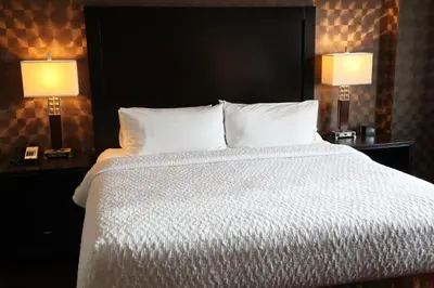 a bedroom with a large bed with two lamps at Homewood Suites Calgary Airport in Calgary