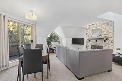 a living room with a table and chairs and a television at 2BR in Gleneagle, Gourmet Kitchen, Newly Updated, Wood Burning Fireplace, Parking in Whistler