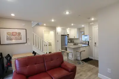 a living room with a couch and a kitchen at Vancouver Traveller Cottage in Vancouver