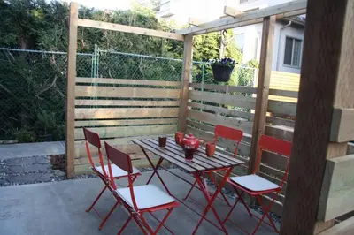 a wooden table and four chairs on a patio at Vancouver Traveller Cottage in Vancouver
