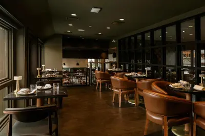 a restaurant with tables and chairs and a bar at Mount Royal Hotel in Banff