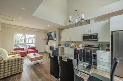 a kitchen and living room with a couch and a table at Family Mountain Escape - Three Townhouses in One in Canmore