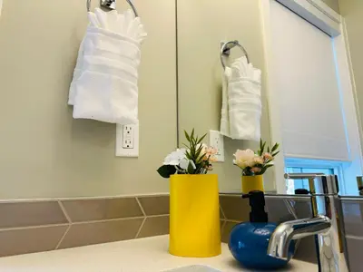 a bathroom with a sink and a mirror and towels at Family Mountain Escape - Three Townhouses in One in Canmore