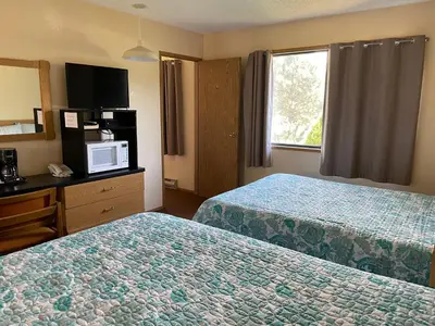 a hotel room with two beds and a television at Y-5 Motel in Barrière