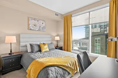 a bedroom with a bed and a large window at GlobalStay Downtown Calgary Condos in Calgary