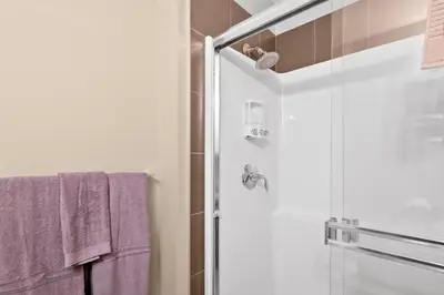 a bathroom with a glass shower with purple towels at GlobalStay Downtown Calgary Condos in Calgary