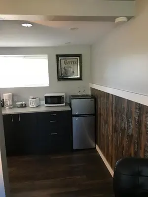 a kitchen with a refrigerator and a counter with a microwave at 94 Motel & RV Park in One Hundred Mile House