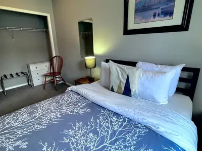 a bedroom with a bed with a blue and white comforter at Canadian Rockies Chalets by Trilink - 2 & 3 Bedroom Condos - Self Check-In - Walking Distance to Downtown - Free Parking - Pet-Friendly - No AC in Canmore