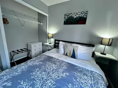 a bedroom with a bed with a blue and white comforter at Canadian Rockies Chalets by Trilink - 2 & 3 Bedroom Condos - Self Check-In - Walking Distance to Downtown - Free Parking - Pet-Friendly - No AC in Canmore