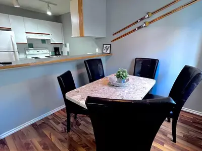 a dining room with a table and chairs and a kitchen at Canadian Rockies Chalets by Trilink - 2 & 3 Bedroom Condos - Self Check-In - Walking Distance to Downtown - Free Parking - Pet-Friendly - No AC in Canmore
