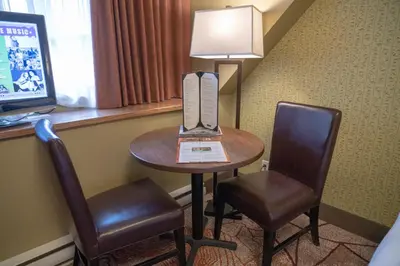 a hotel room with a table with a laptop and two chairs at Banff Caribou Lodge and Spa in Banff