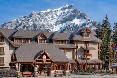 a large building with a mountain in the background at Banff Caribou Lodge and Spa in Banff