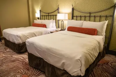 a hotel room with two beds with white sheets at Banff Caribou Lodge and Spa in Banff