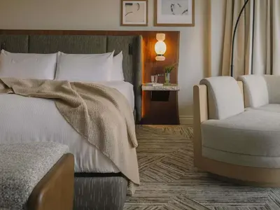a bedroom with a bed and a chair in it at Rimrock Banff, Emblems Collection in Banff
