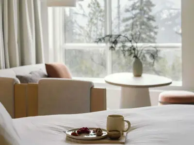 a plate of food on a bed in a room at Rimrock Banff, Emblems Collection in Banff