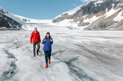 a man and a woman walking on the ice at Banff Park Lodge in Banff