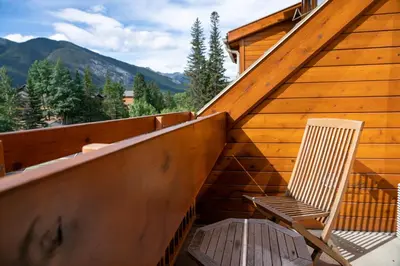 a chair sitting on the balcony of a cabin at Fox Hotel and Suites in Banff