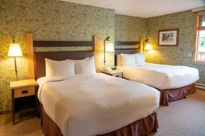 a hotel room with two beds and two lamps at Fox Hotel and Suites in Banff