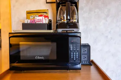 a microwave with a coffee maker on top of it at Bow View Lodge in Banff
