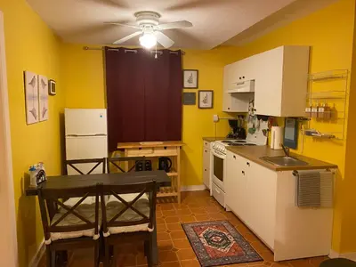 a kitchen with yellow walls and a ceiling fan at Five Elements Lodge B&B with Outdoor Spa in Fernwood