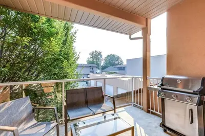 a balcony with a grill and a glass table at Grandma's Elephant Hideaway in Penticton